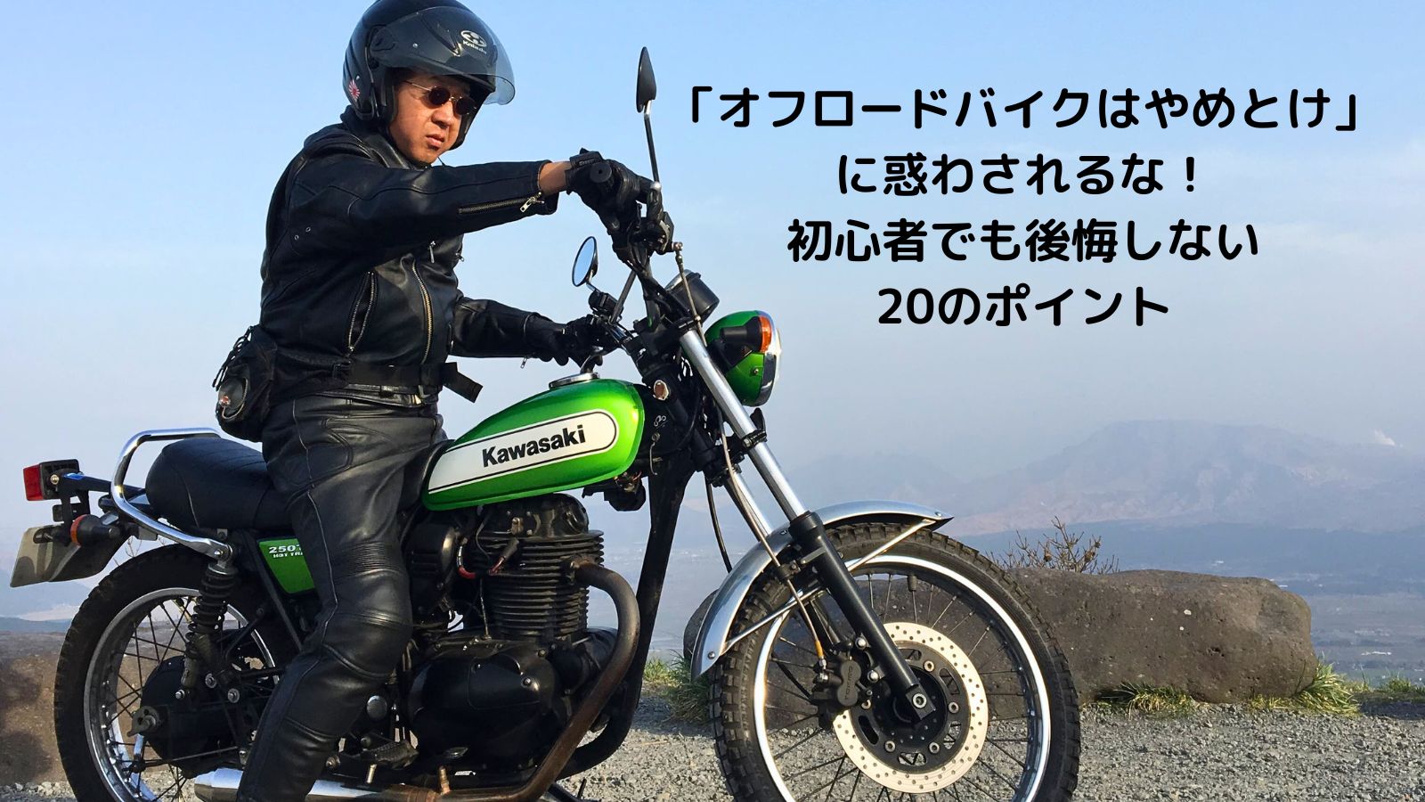 バイク歴40年の筆者が愛機カワサキ250TRに乗って阿蘇大観峰の砂利の展望所に立つ、オフロードバイクのアイキャッチ画像。