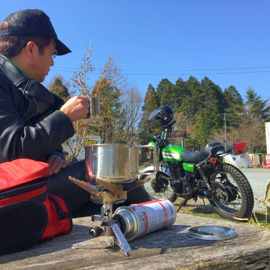 オートバイキャンプでバーナーを使いコーヒーを楽しむ筆者。ツーリングに最適なバーナーの選び方を実体験で解説。