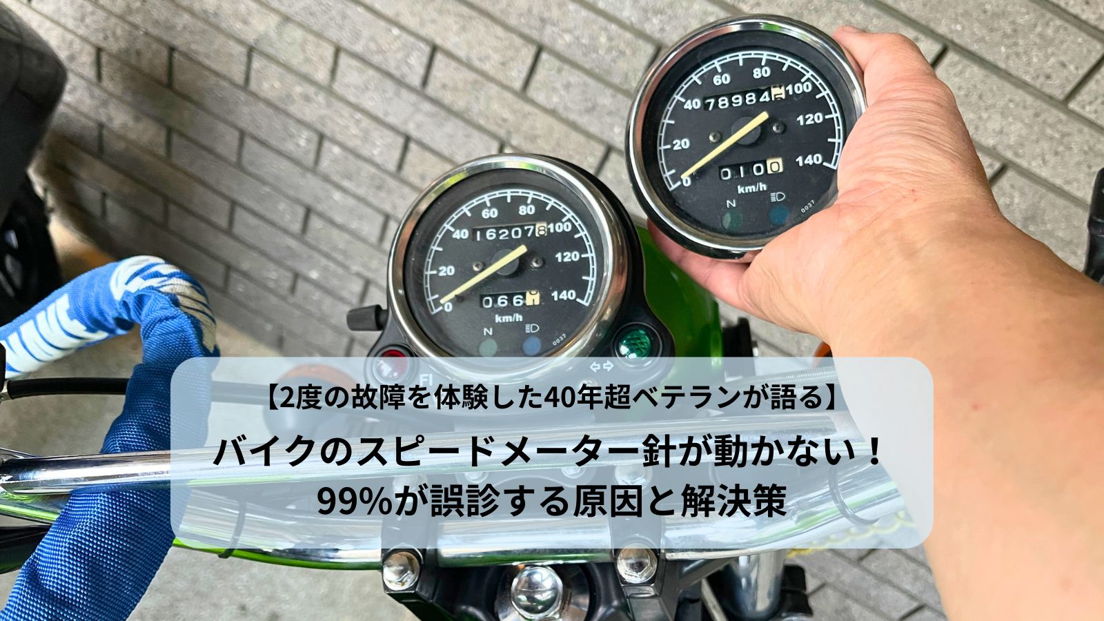 バイクのスピードメーター針が動かない故障で交換した新旧メーター。手には7万9千kmで壊れたメーター、バイク本体には交換後の中古メーターが写っている。