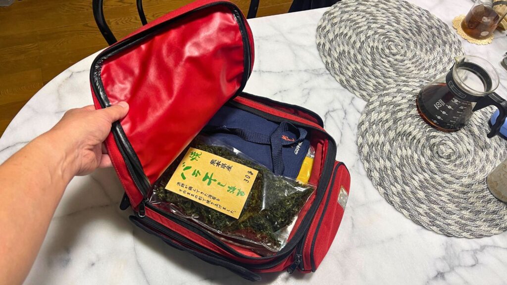 バイクのタンクバッグに積載された熊本土産「焼バラ干し海苔」。他の荷物と一緒に無理なく収まり、超軽量でかさばらないことを証明している写真。
