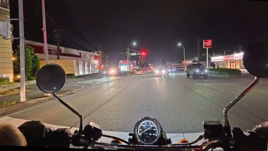 バイク盗難防止に最強の立地条件。夜間でも常夜灯で明るい国道沿いで、車や人の往来が多く「人目(目撃リスク)」があるため、泥棒が犯行を諦める駐輪環境の実例画像