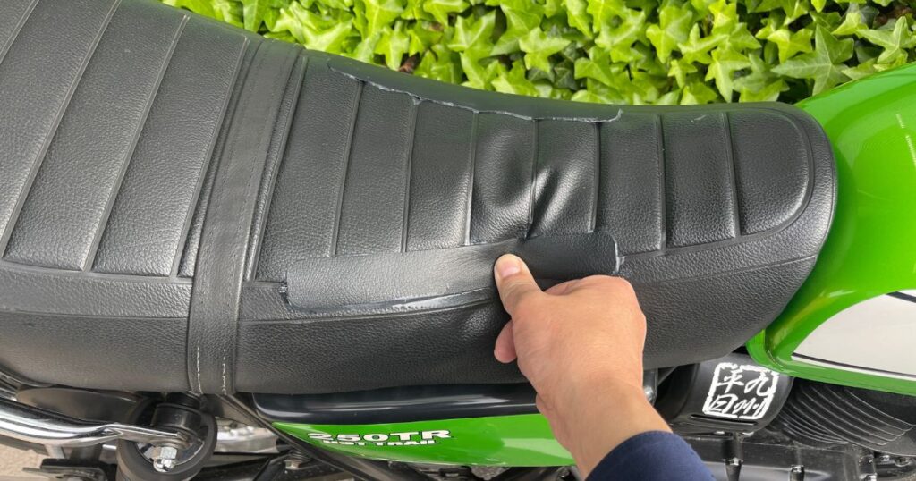 24時間の硬化を終えた250TRのシート補修箇所を親指で強く押し、合成皮革の追従性と接着強度を確認するテスト。